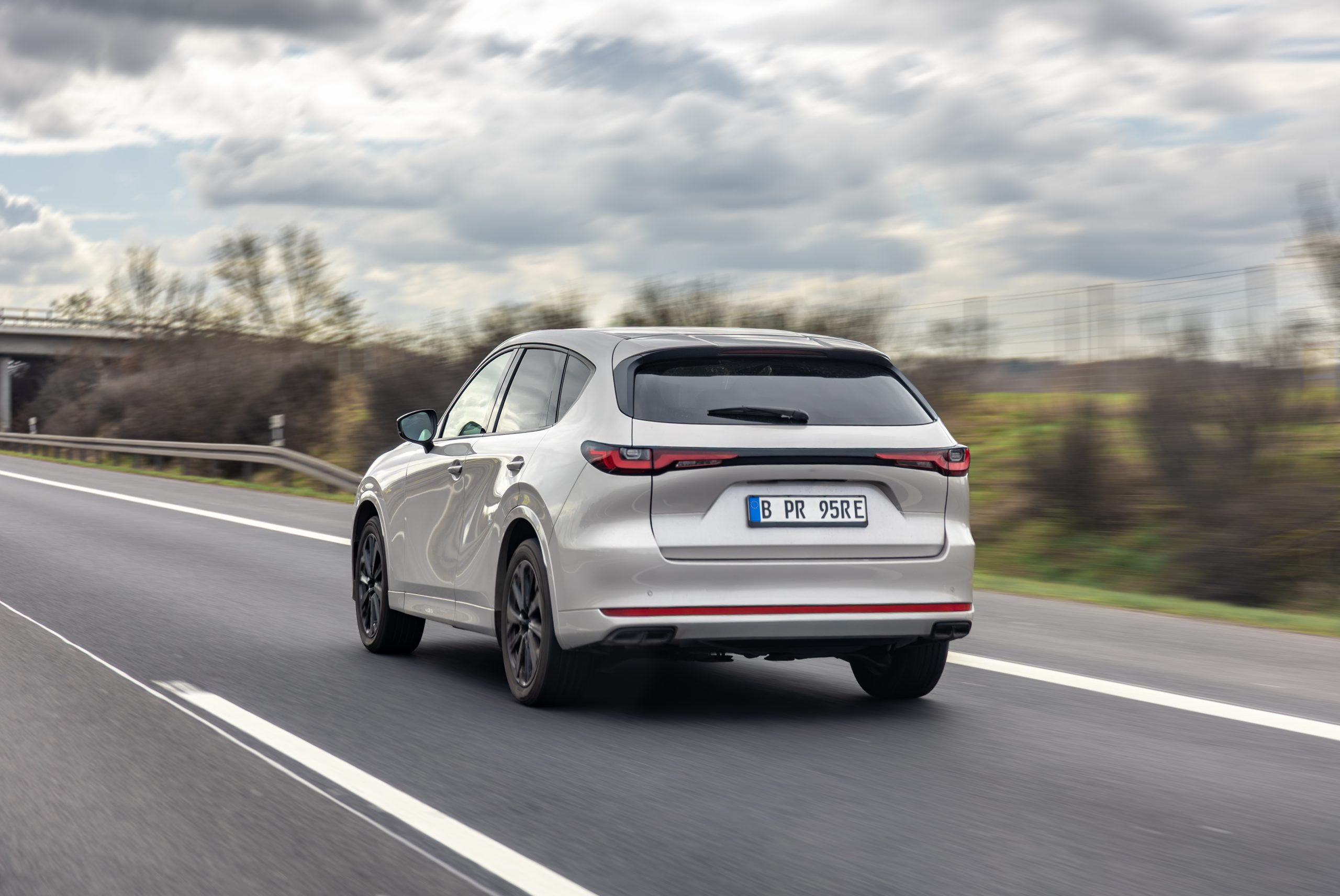 Side-rear view of a silver premium SUV driving on a country highway with motion blur. Contemporary automotive design. SSUCv3H4sIAAAAAAAAA41Py46DMAz8F59B4pGlXX6l2kNIHGoVSJWYrVYo/16HUvW6Oc144pnxBmShB1c3TjWqKtsv15R17epyODssK9s5d+q+G2UcFGA1I/R1q5qqayvVtadzW8krYNCRDPQb0DStkYNm8gv0ogRcLIYdoiX2gfQkLBUQWfMaMcqaMCPeo6g7f/tdtjyXghIe1yGDVPxz9lOAHnExf9k/5SIT6j3uItLtwRjmI9vzNVfM8B7I0DIeneQUP7/w4jnv7gnszY3ssfw640oyDTkL1vvktUV7yOswE/ObBvwlfHx+p5SeILt1ZYQBAAA=